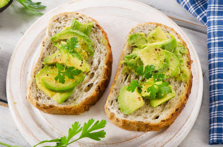 Homemade healthy sandwiches with avocado and fresh herbs. Selective focus