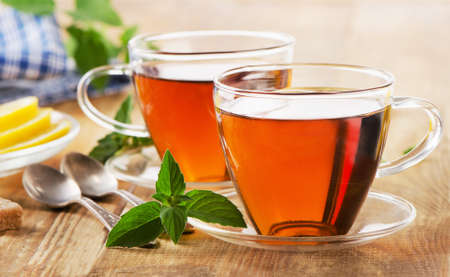 Cups of tea with mint and lemon on  wooden table. Selective focusの写真素材