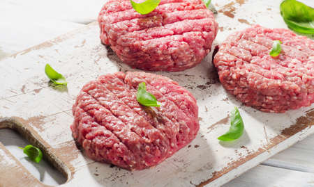 Raw Ground beef Burger steak patties on wooden cutting board. Top viewの写真素材