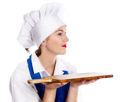 Portrait of smiling woman chef with cutting board isolated on whiteの写真素材