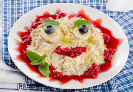 Smiling oatmeal and fresh berries for a healthy breakfast. Selective focusの写真素材