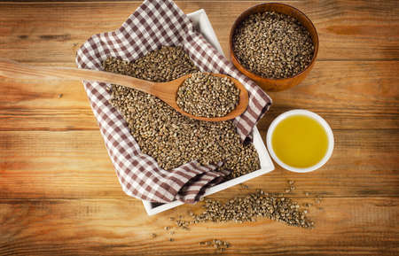 Hemp seeds and hemp oil on a wooden background. Top viewの写真素材