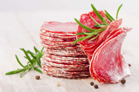 Slices of salami sausage on a wooden table. Selective focusの写真素材