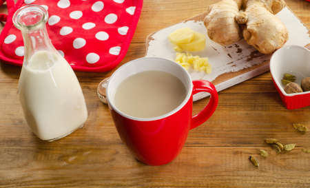 Ginger tea with milk in a cup on a wooden background. Selective focusの写真素材