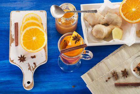 Ginger tea with orange, spices and honey in glass cup. Top viewの写真素材