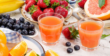 Citrus juice, fruits and berries on a wooden background. Healthy eating. Top viewの写真素材