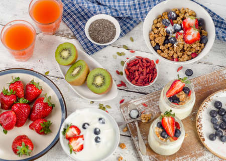 Healthy breakfast with muesli, yogurt, juice, fruits and superfoods. Top view