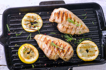 Grilled chicken breast and spices on grill pan. Top view