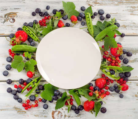 Fresh summer berries  mix - blueberries, strawberries, red currant and green peas. Healthy food concept.の写真素材