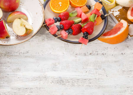 Preparing a fresh fruit salad on white wooden  background. Top viewの写真素材