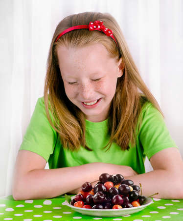 Funny little girl with sweet berries. Healthy food.