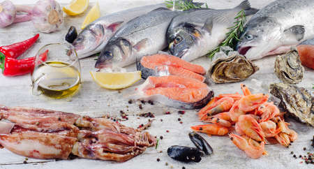 Raw fish and seafood with fresh aromatic herbs and spices. Healthy diet eating.の写真素材