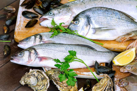 Fresh raw seafood on a wooden board. Healthy eating.の写真素材