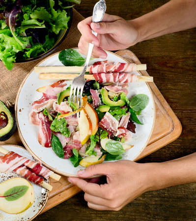 Woman hands with fresh salad. Top viewの写真素材