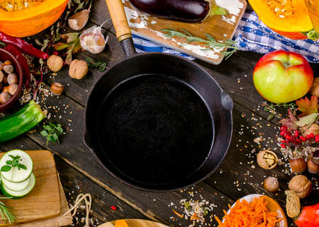 Iron pan with Autumn fruits and vegetables  on a  dark wooden background. Top viewの写真素材
