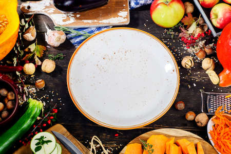 Plate with Autumn fruits and vegetables  on a dark wooden background.の写真素材