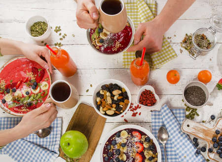 Healthy Breakfast with fresh berries smoothie bowls and superfood on a white wooden table. Detox eating concept. Top viewの写真素材