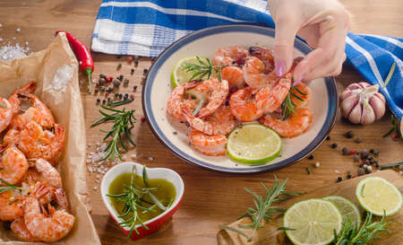 Woman hands with grilled shrimps. Healthy diet food concept. Top viewの写真素材