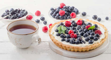 Sweet Cheese cakes with fresh berries and tea cup.の写真素材