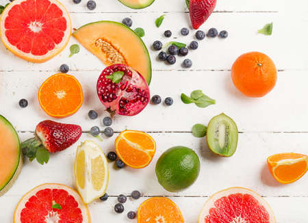 Mixed fruits on white wooden background. Healthy food concept. Pattern. Top view