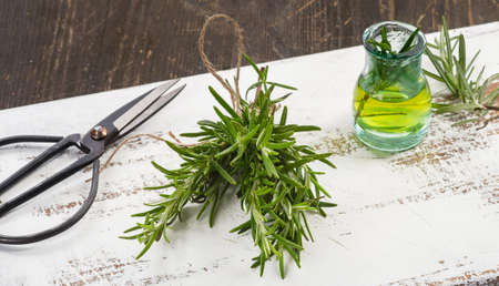 Fresh Rosemary  and oil on a wooden boardの写真素材