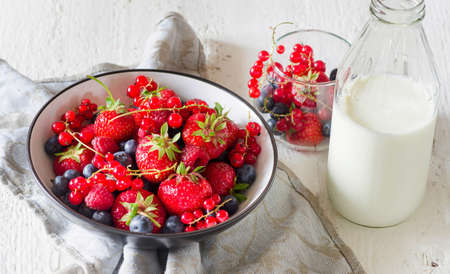 Morning healthy breakfast with berries on a white wooden tableの写真素材