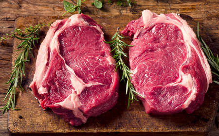 Raw meat Ribeye Steak with seasoning  on dark wooden background. Top viewの写真素材