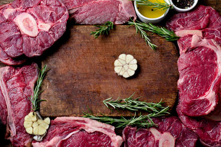 Raw agged beef on a dark wooden board. Food high in proteinの写真素材