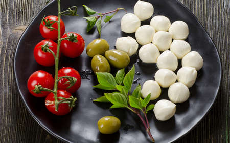 Plate of mozzarella balls, cherry tomatoes and fresh basilの写真素材