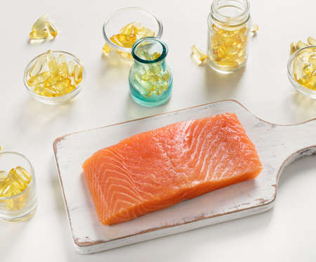 Fish oil capsules and salmon fillet.の写真素材