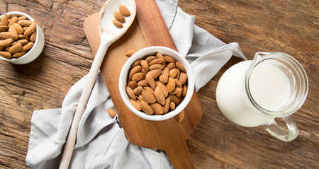 Almonds in bowl on wooden background.の写真素材
