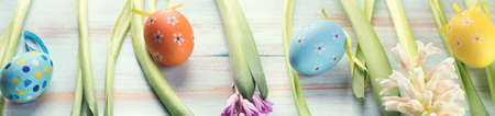 Spring flowers with easter eggs on a blue wooden background