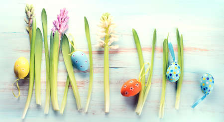 Spring flowers with easter eggs on a blue wooden background
