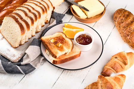 Cutting board with toast bread, jam and butter on table. Top viewの写真素材