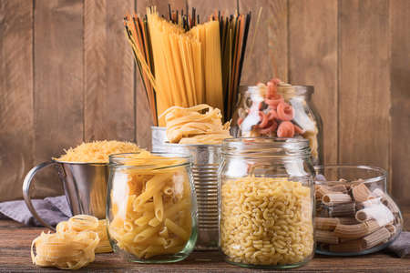 Different types of Italian pasta  for healthy cooking on wooden table.の写真素材