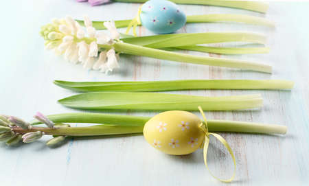 Spring flowers with easter eggs on a blue wooden background