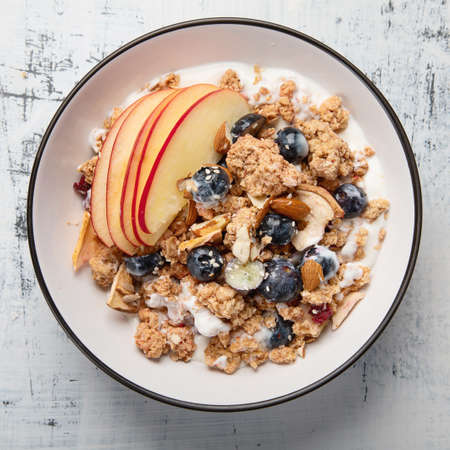 Bowl of granola with yogurt and fresh fruits for healthy breakfast. 