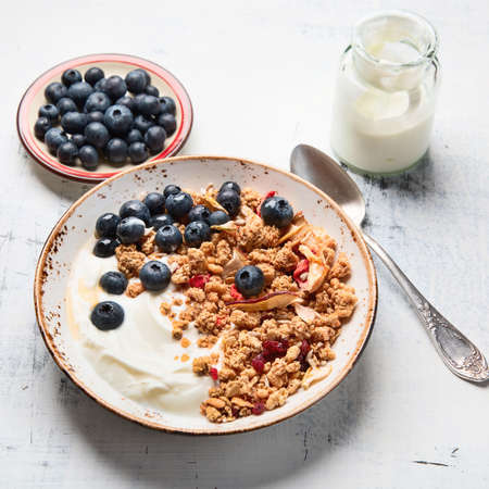 Bowl of granola with yogurt and fresh blueberries for healthy breakfast. 