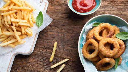 Crunchy fried onion rings on wooden backgroundの写真素材