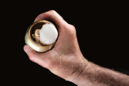 Beer can in hand on black backgroundの写真素材