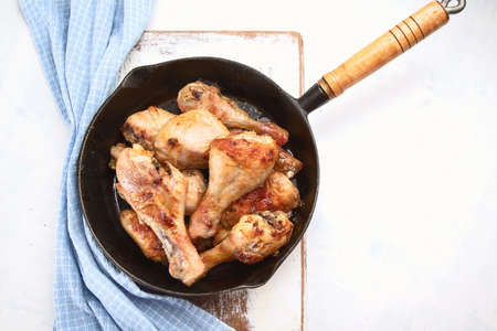 Fried chicken legs in  iron frying pan. Top viewの写真素材