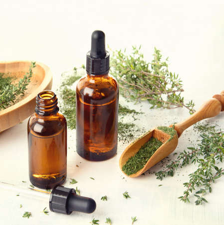 Thyme essential oil with fresh thyme twigsの写真素材