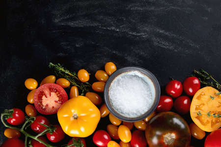 Colorful tomatoes on black background. Top view, flat lay with copy space. Healthy food conceptの写真素材