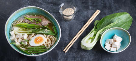 Asian beef noodle soup on dark background. Top view. Panorama, banner