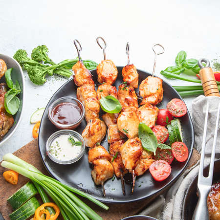 Grilled chicken meat meals on table. Assortment of tasty bbq snack with fresh vegetablesの写真素材