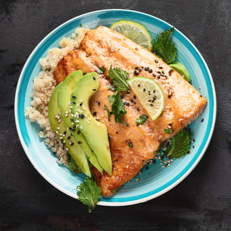 Grilled salmon with avocado, quinoa and sesame on black