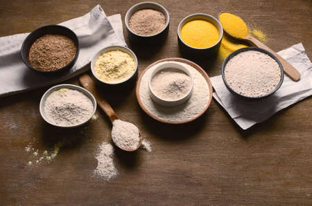 Different types of baking flour on wooden table. Top view with copy spaceの写真素材