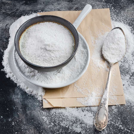 Bowl of white table salt on black background.の写真素材