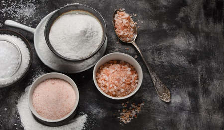 Different types of salt on black background. Top view with copy spaceの写真素材
