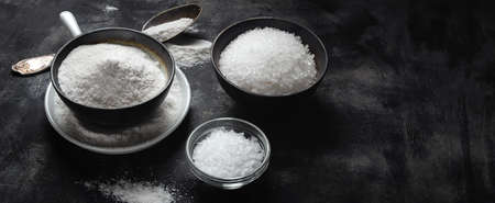 Regular Table Salt and Sea Salt on black